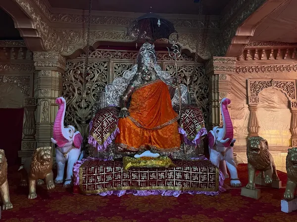 Temple & Worship: The temple shrine, with the seated figure of Acharya Swami Pranavananda flanked by carved lions and elephants